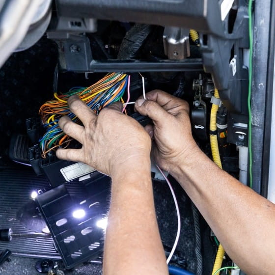 Experienced technicians working on vehicle wiring systems.