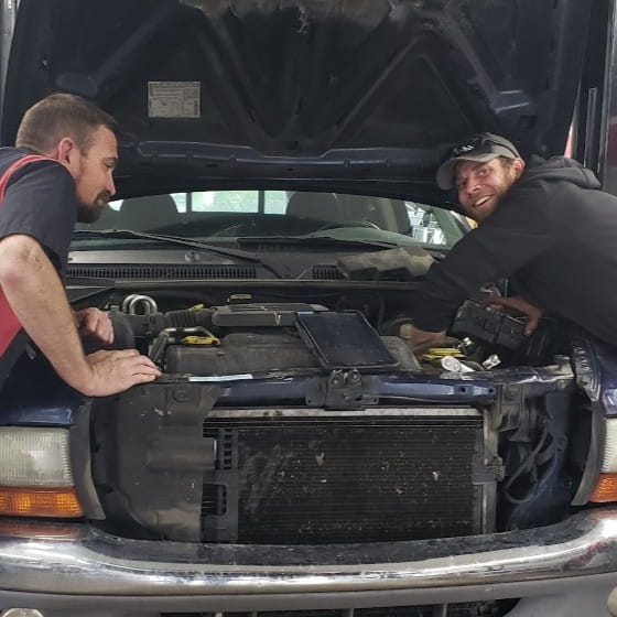Auto repair technicians inspecting vehicle engine at Boise Muffler.