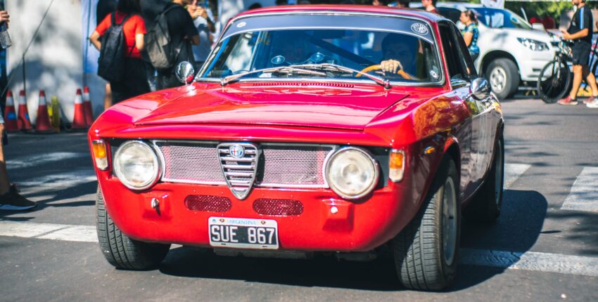 Vintage red Alfa Romeo parked at Boise Muffler Auto Repair event.
