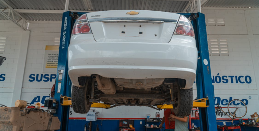 Chevrolet Cruze lifted on a hydraulic lift during suspension upgrade.