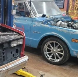 Classic blue muscle car with custom wheels at Boomer’s Performance & Offroad.