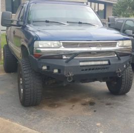 Custom offroad truck with lifted suspension and rugged tires.