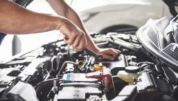 Mechanic inspecting a vehicle engine for offroad performance upgrades.