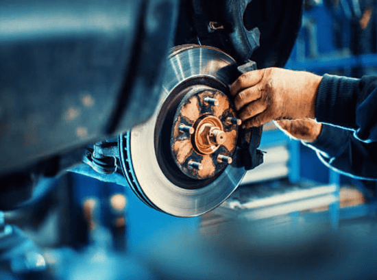 Mechanic inspecting a vehicle during routine maintenance at an automotive repair shop