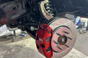 Brake rotor and red caliper on vehicle.