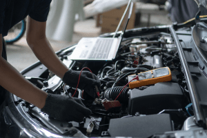 Automotive technician inspecting engine with diagnostic tools at Butterworth's Service Centre.