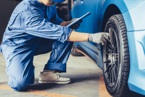 Technician inspecting a car tire at Butterworth's Service Centre.