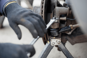 Mechanic working on car suspension at Butterworth's Service Centre.