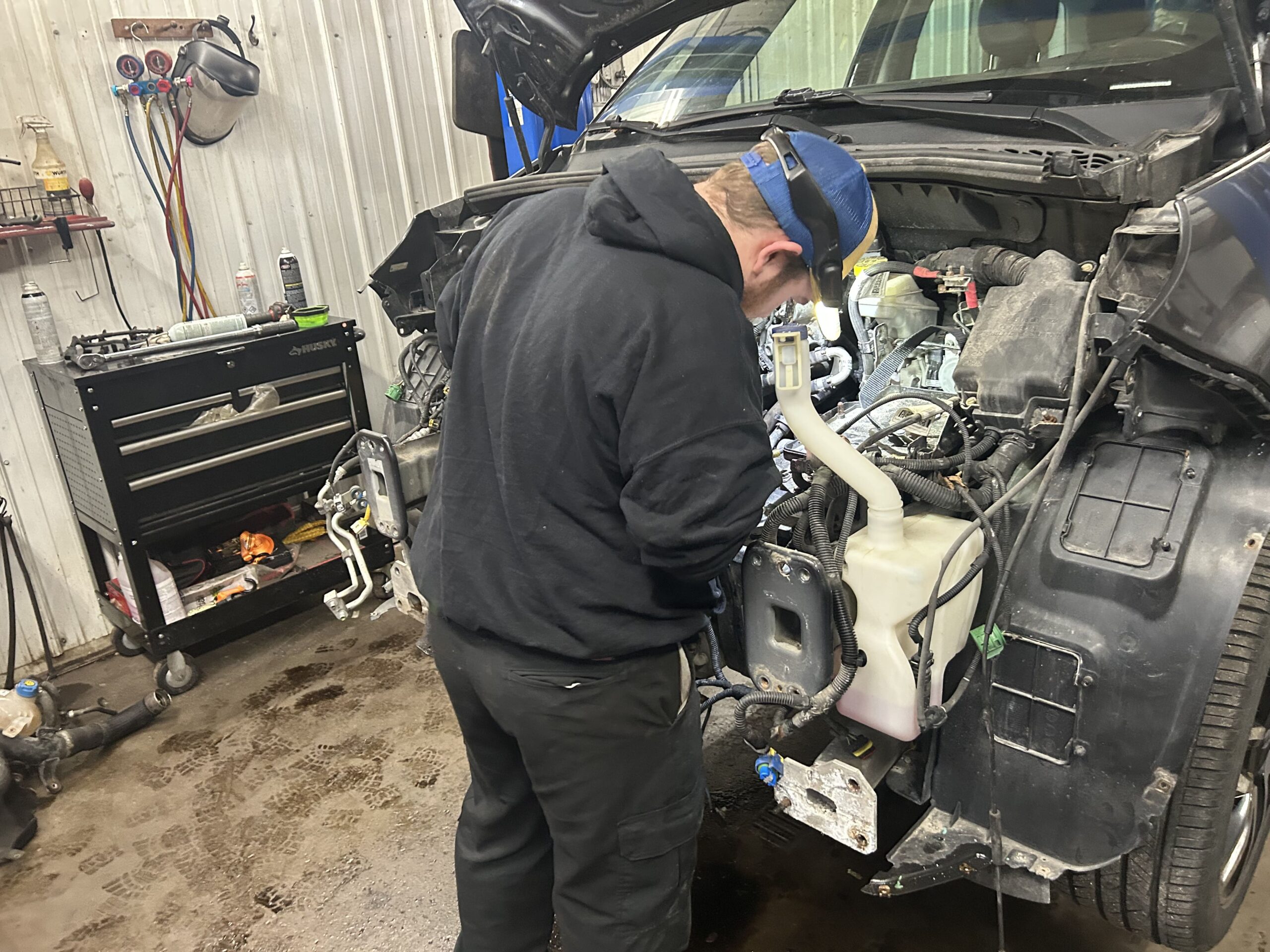 Skilled mechanic working on vehicle engine at Butterworth's Service Centre.