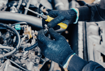 Auto mechanic inspecting engine with tools at Butterworth's Service Centre.