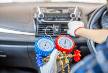 Auto air conditioning service tools and gauges in use.