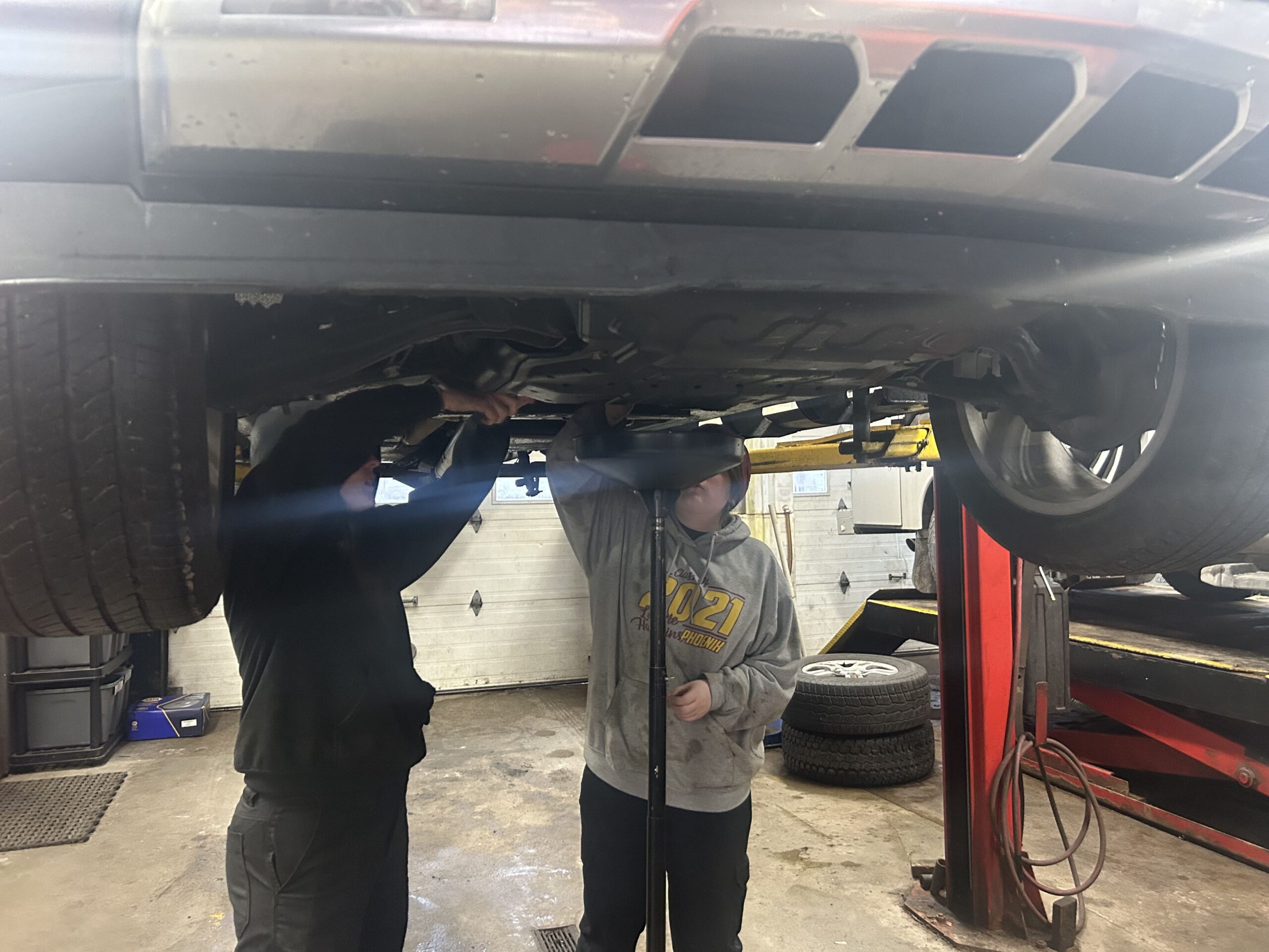 Service technicians inspecting vehicle underside at Butterworth's Service Centre.
