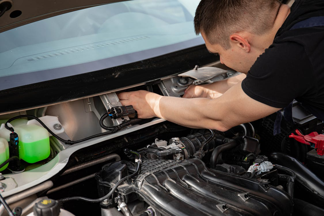 Engine repair technician diagnosing car engine issues at Butterworth's Service Centre.