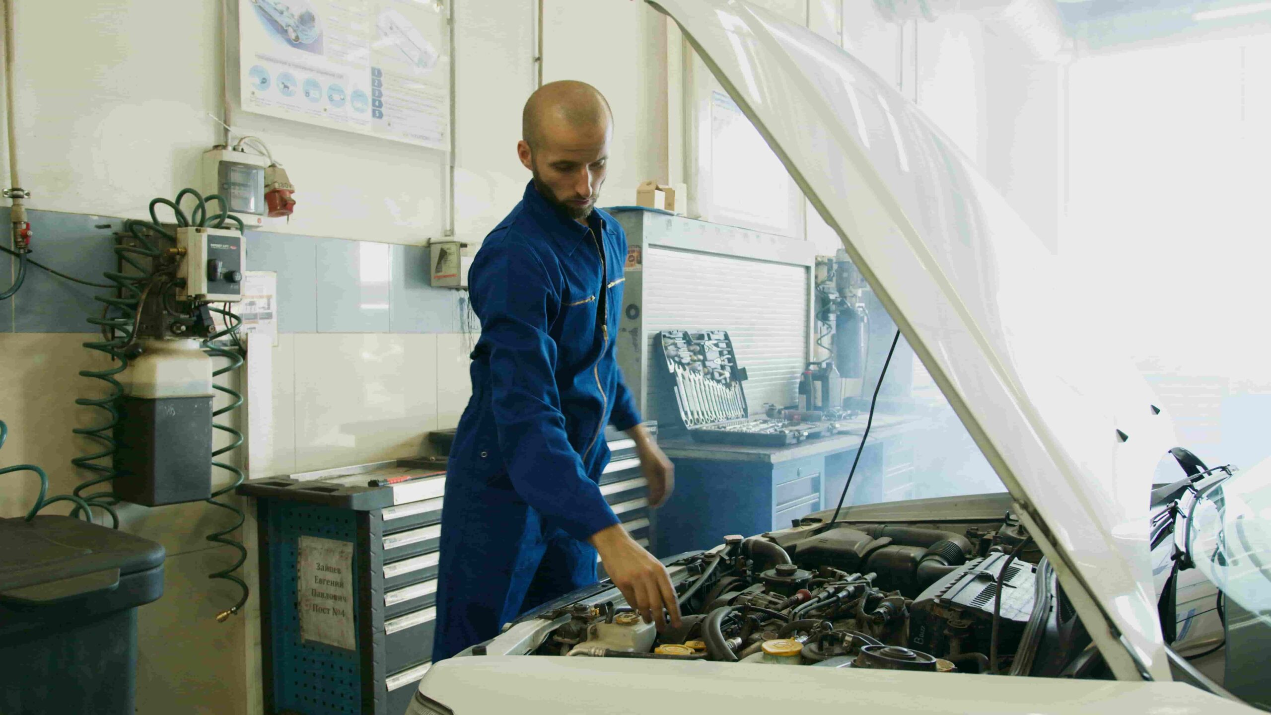 Technician inspecting car engine during routine maintenance at Butterworth's Service Centre.