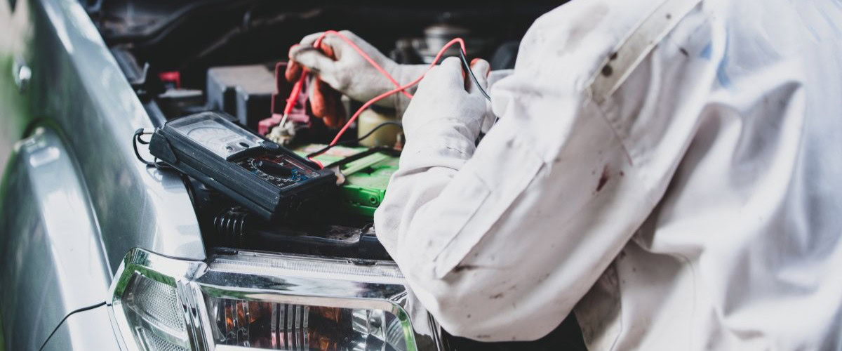 Electrical & HVAC technician performing diagnostics on a vehicle's electrical system.