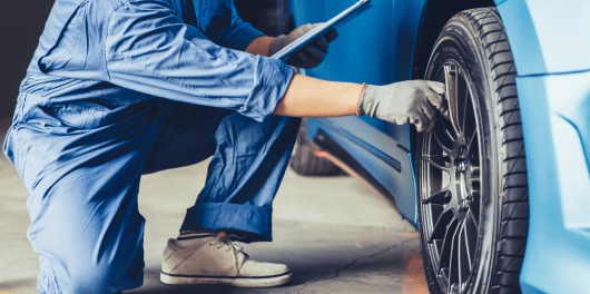 Technician inspecting a car tire at C&D Automotive Service in Texas.