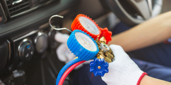 AC repair tools and gauges inside a vehicle for maintenance.