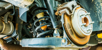 Suspension repair service showing vehicle suspension components and coil spring.