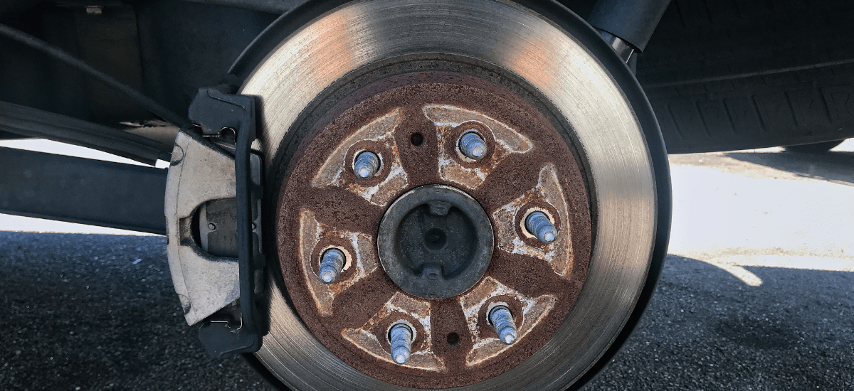Close-up of a car brake disc and caliper at Car Corral Garage.