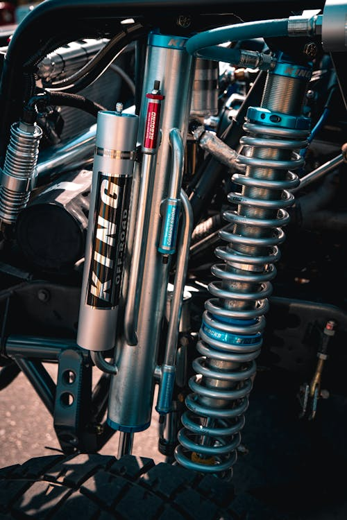 Close-up of motorcycle suspension components showing shock absorbers and coil springs.