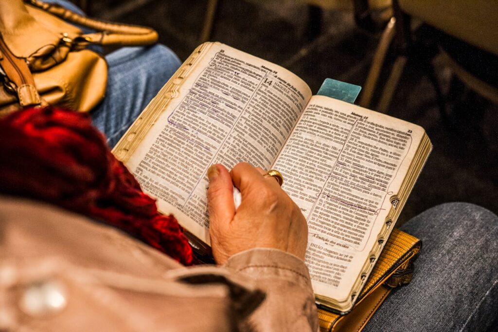 pexels-photo-1296720 A person reading a Bible indoors, symbolizing spirituality and devotion.