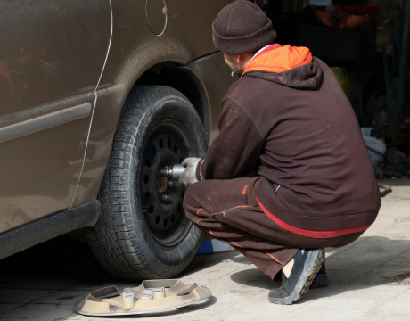 Technician inspecting a car tire for safety and wear in Montreal.