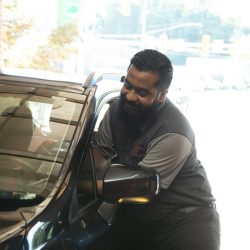 Auto technician inspecting vehicle at C&H Automotive.