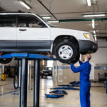 Auto repair technician inspecting a vehicle on a lift at Clay’s Auto Service.
