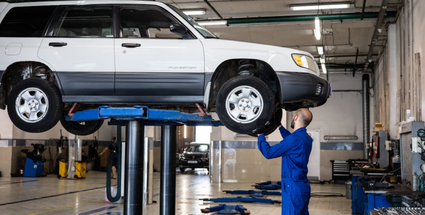 Auto repair technician inspecting a vehicle on a lift at Clay’s Auto Service.