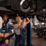 male-female-mechanics-working-shop-car