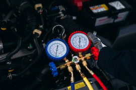 Auto AC refrigerant service gauges for vehicle air conditioning repair.