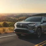 Toyota RAV4 SUV driving on a scenic road during sunset.