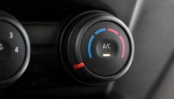 Close-up of car A/C temperature control knob with blue and red indicators.