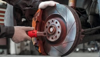 Technician replacing brake disc on vehicle at Cliffs Edge Automotive.