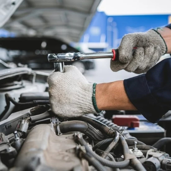 Technician performing engine tune-up at Cliffs Edge Automotive.