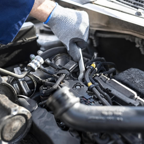 Technician performing engine tune-up at Cliffs Edge Automotive.