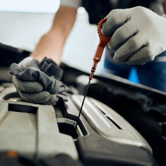 Technician performing oil change on vehicle engine at Cliffs Edge Automotive.