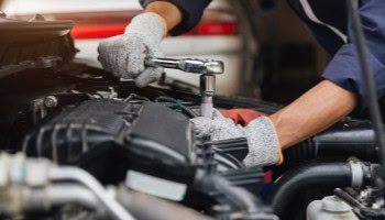 Technician repairing car engine at Cliffs Edge Automotive.