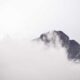 Mountain peak with clouds and mist, creating a mysterious and serene landscape.