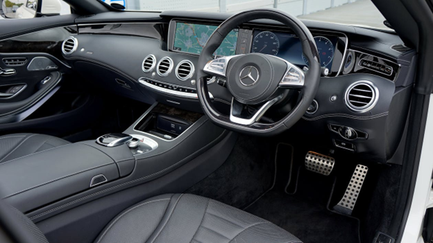 Modern car interior showing steering wheel and dashboard with suspension focus.