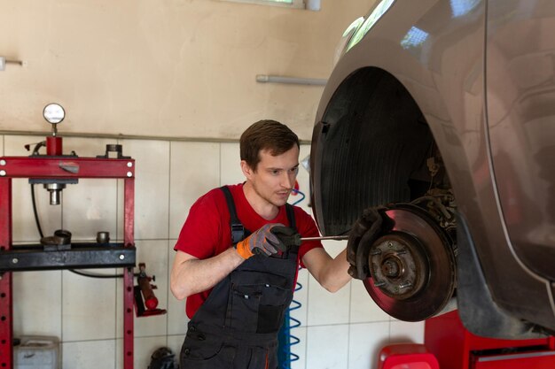 Auto mechanic inspecting timing belt and chain in vehicle at Cochrane Automotive.