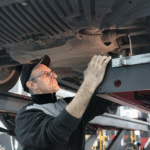 Mechanic inspecting vehicle undercarriage at Country Tires & More.