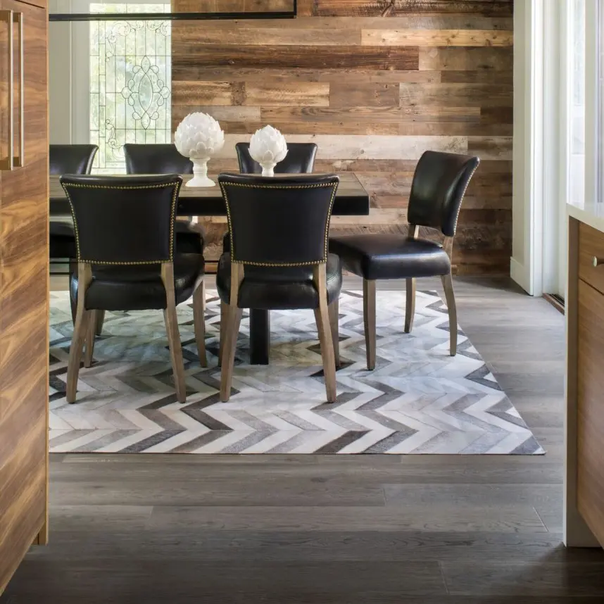 Modern dining room with stylish wood floors and black leather chairs.