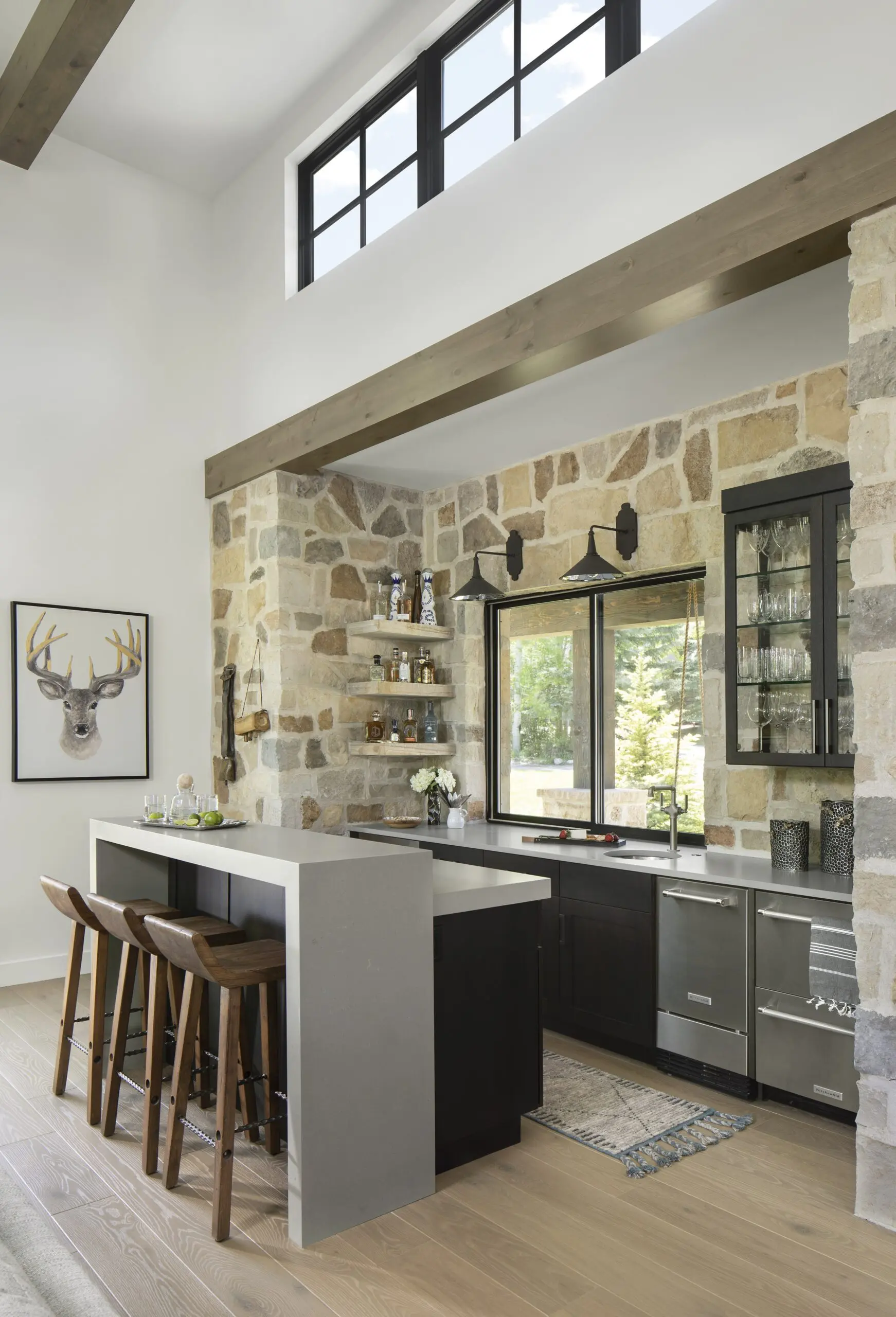 Smooth natural wood flooring in modern kitchen setting with stone accents and black cabinetry.