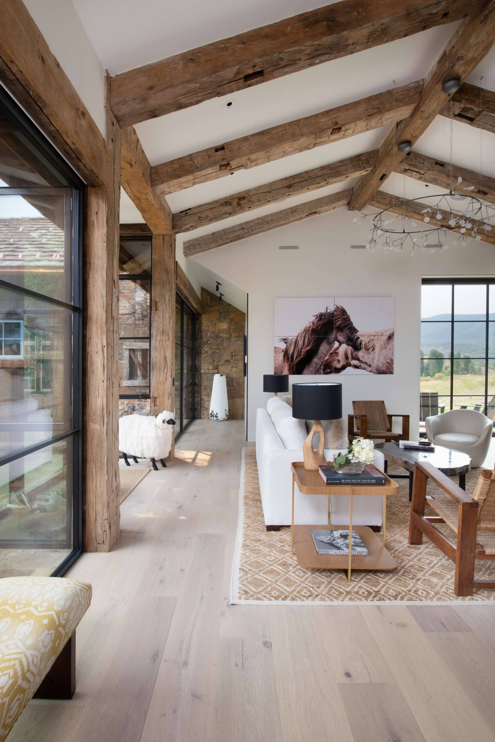 Cream-colored wood flooring with natural wood beams in a modern mountain home interior.