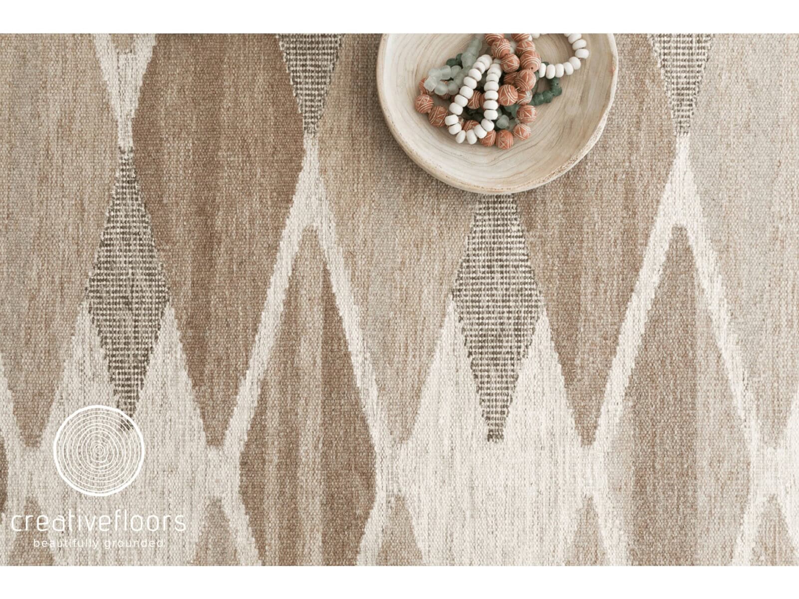 Soft beige geometric area rug with tribal-inspired pattern for stylish floor covering.
