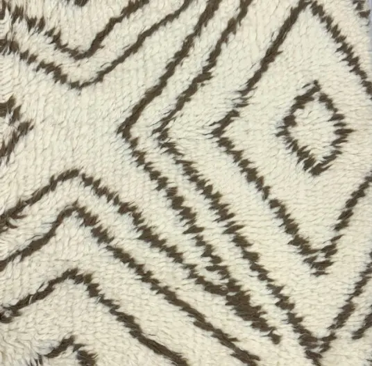 Fuzzy geometric patterned area rug with cream and dark brown design.