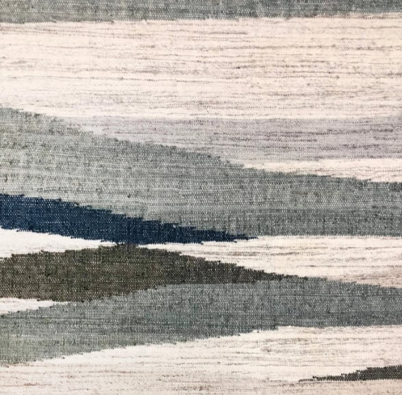 Handwoven modern area rug with abstract geometric pattern in neutral tones.