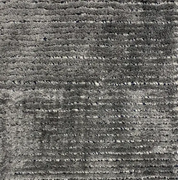 Soft gray textured carpet with modern design for residential or commercial spaces.