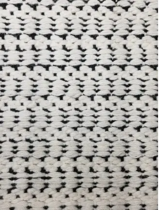 Soft woven rug with black and white geometric pattern for home decor.